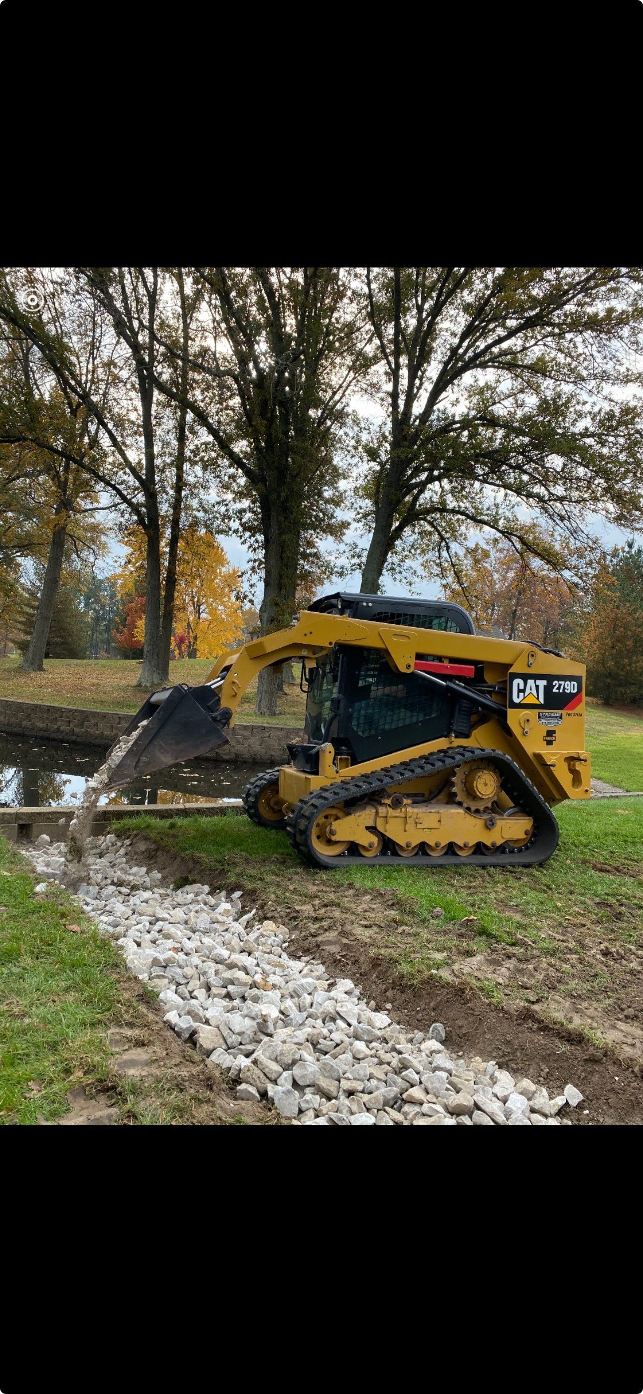 a bulldozer is digging a hole in the ground in a park .