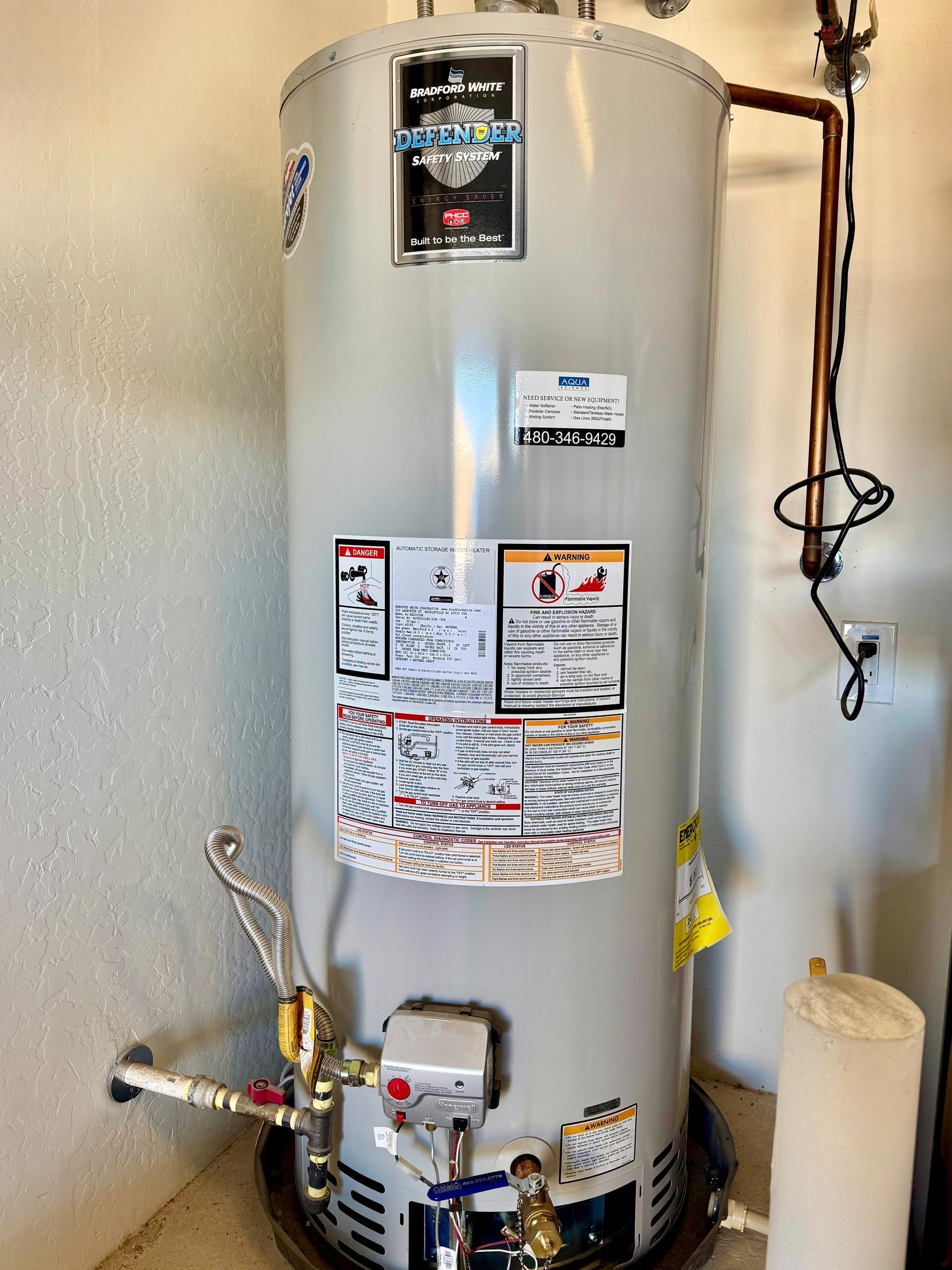 A water heater is sitting in a room next to a wall.