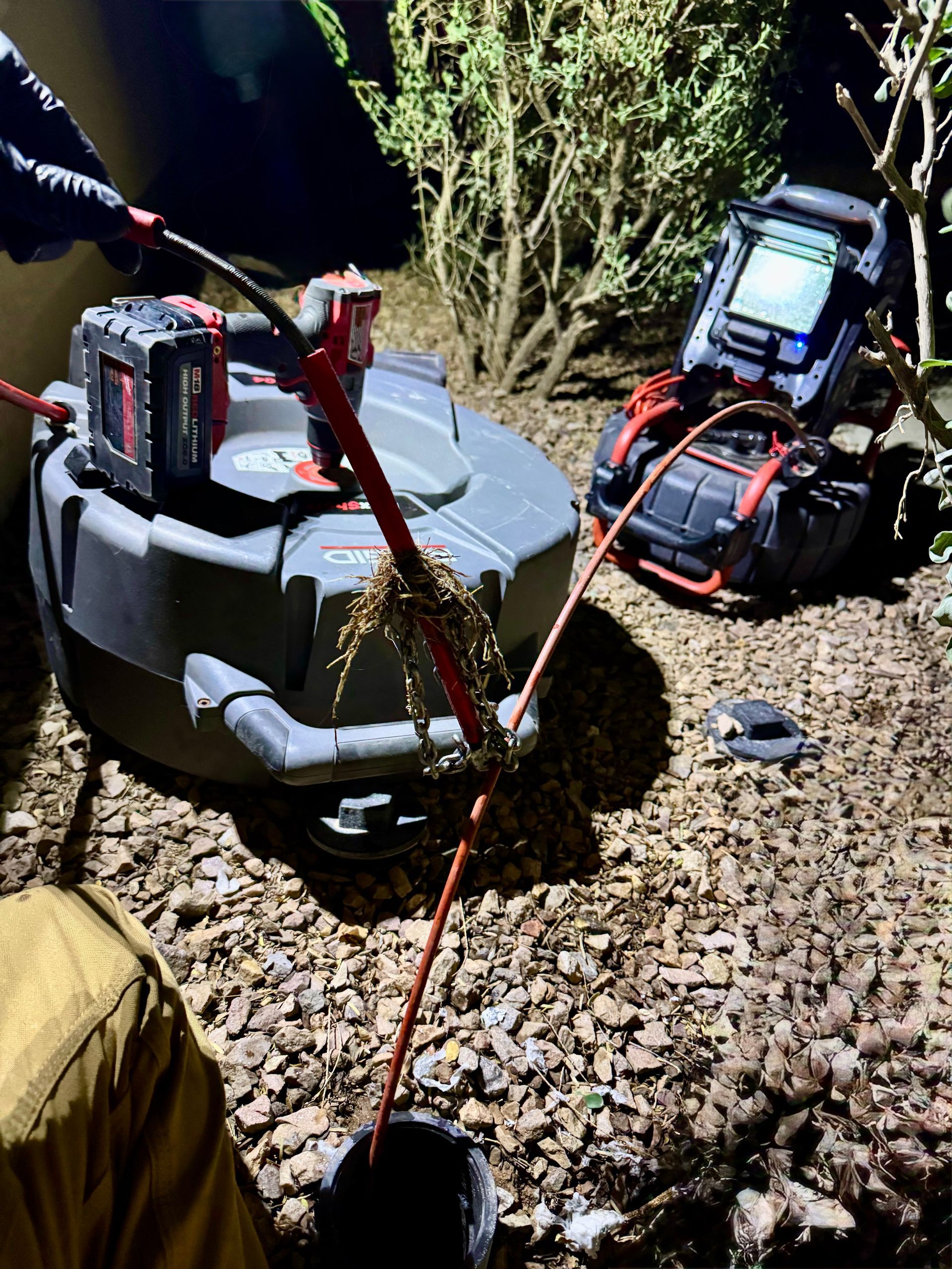 A person is using a hose to clean a pipe.