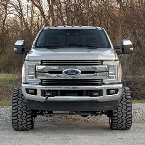 Silver Ford pickup truck with large tires.
