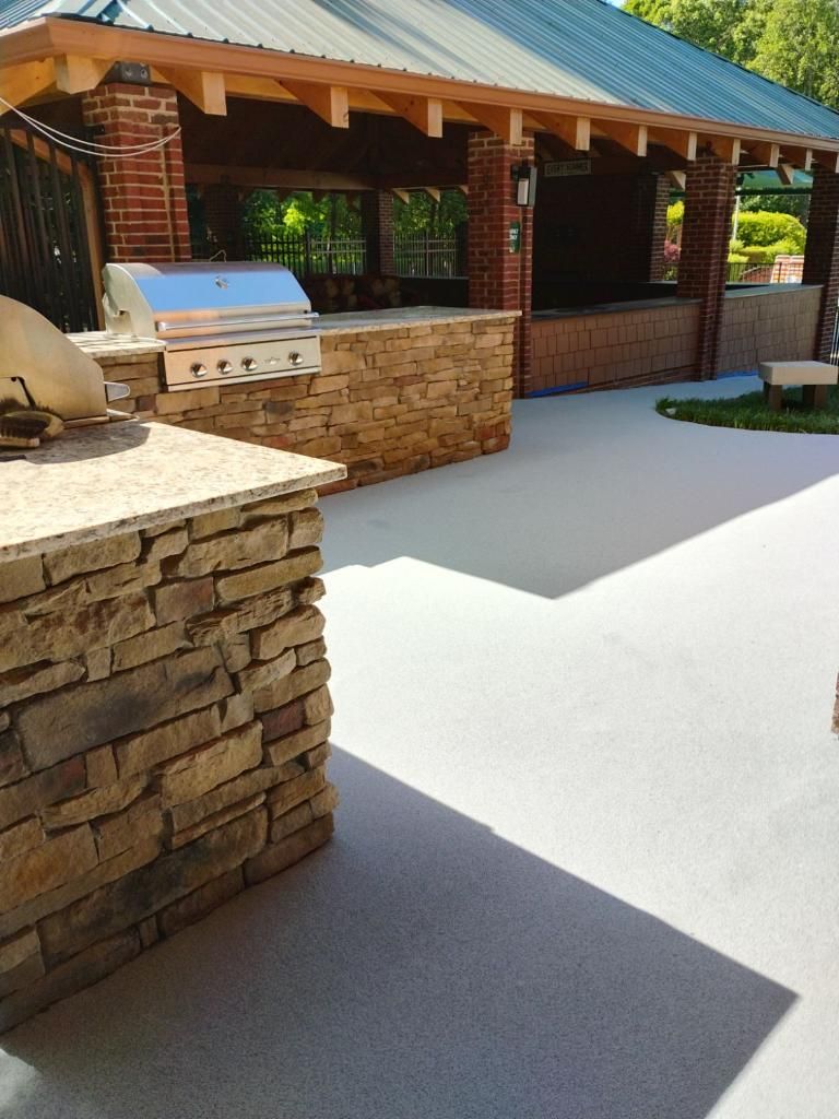 A patio with a grill and a brick wall