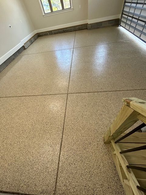 A garage with a concrete floor and a wooden staircase.