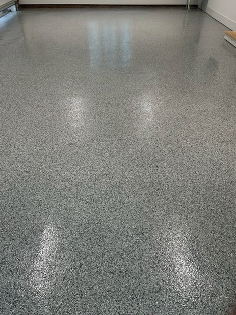 A close up of a shiny gray floor in a room.