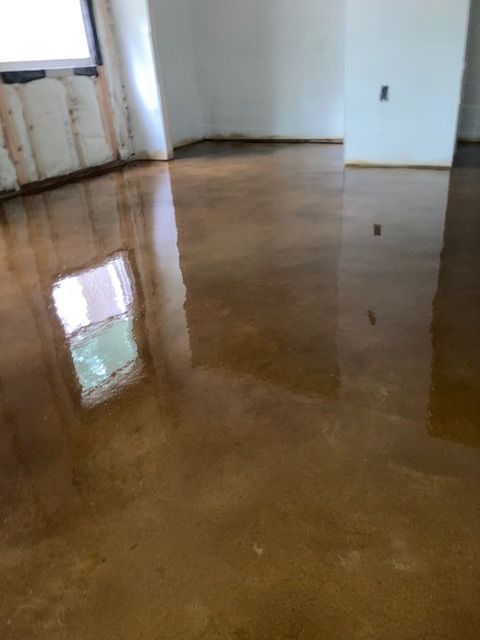 A room with a shiny concrete floor and a window.