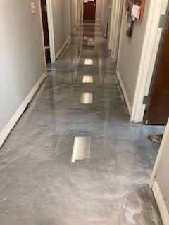 A long hallway with a shiny metallic floor in a building.