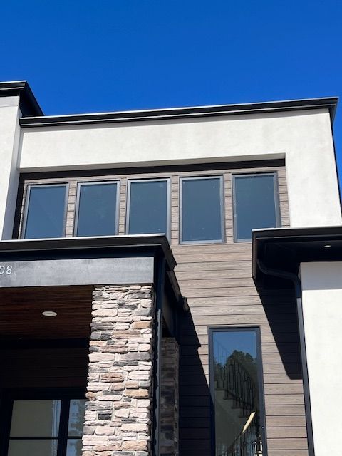 A house with a lot of windows and a blue sky in the background