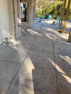 A concrete patio with a brick building in the background.