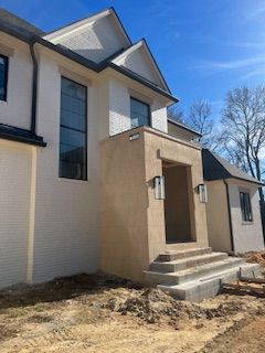 A large white house with black windows is being built.