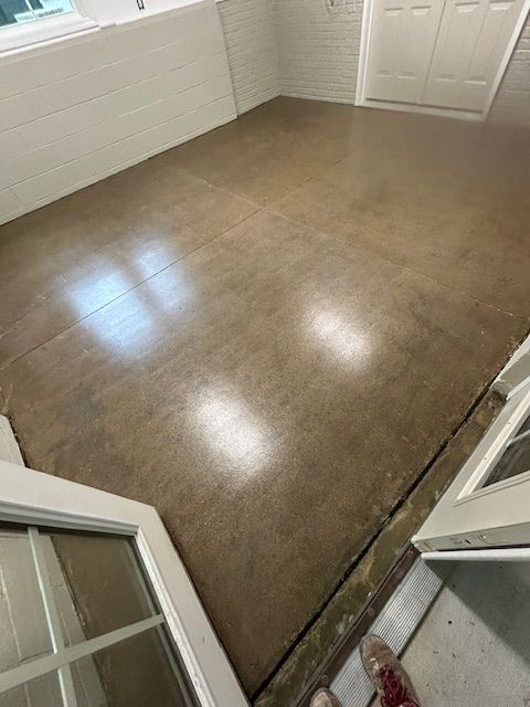 A person is standing on a concrete floor in a room.