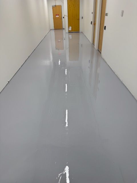 A long hallway with a gray floor and white walls.