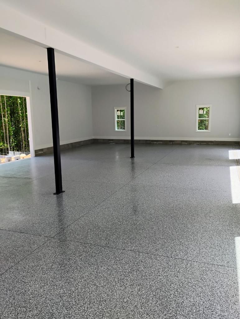 A large empty room with a gray floor and white walls.