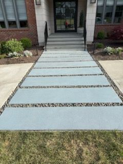 A concrete walkway leading to the front door of a house.