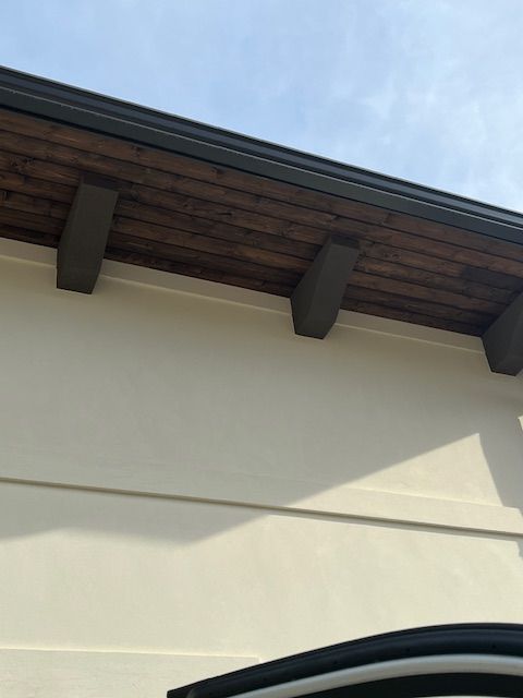 A white building with a wooden roof and a window