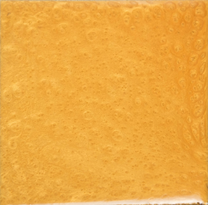 A close up of a yellow tile with a white border
