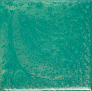 A close up of a green tile with bubbles on it.