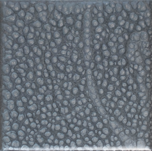 A close up of a gray tile with a polka dot pattern.