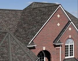 Brick house with a dark gray shingle roof. White trim, arched windows.