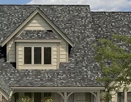 House roof with grey and blue shingles, dormer window.
