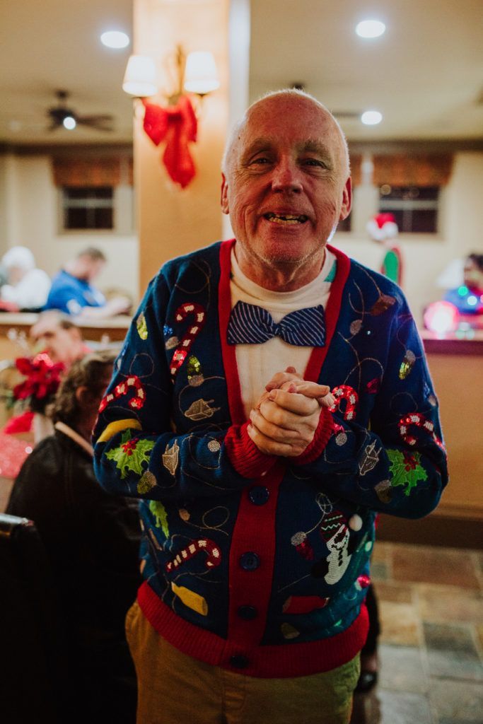 A man wearing a sweater with bow tie.