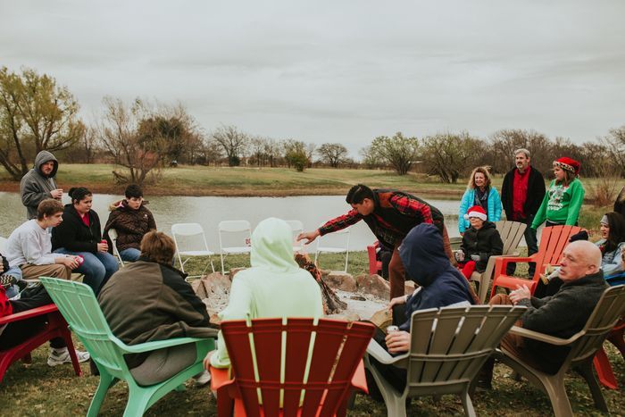 A group of people are sitting around a fire pit.