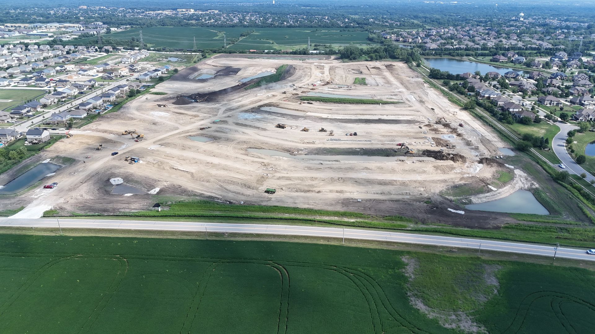 Aerial view of a large construction site, clearing land for a new suburban housing development.