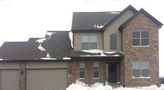 A long hallway with hardwood floors and white walls in a house.