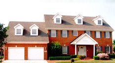A brick house with a garage and a concrete driveway