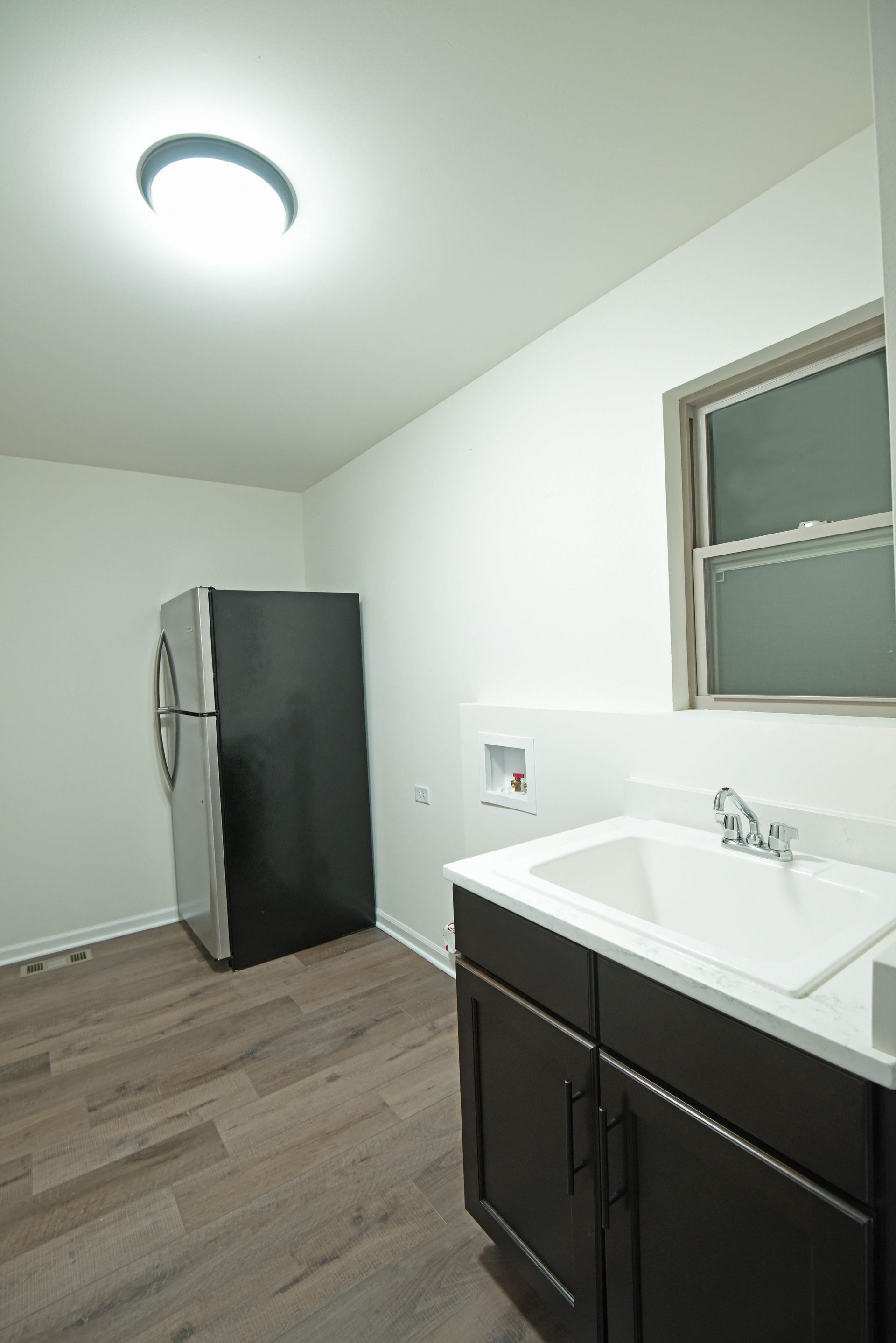 An empty basement with a wooden ceiling and stairs.