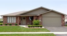An empty kitchen with hardwood floors and stainless steel appliances