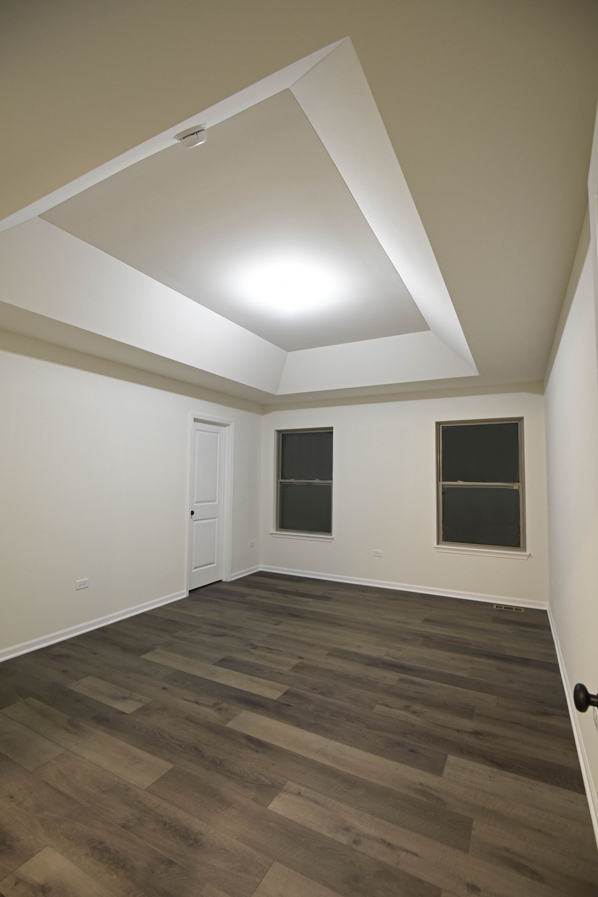 An empty house with a ceiling fan and a kitchen