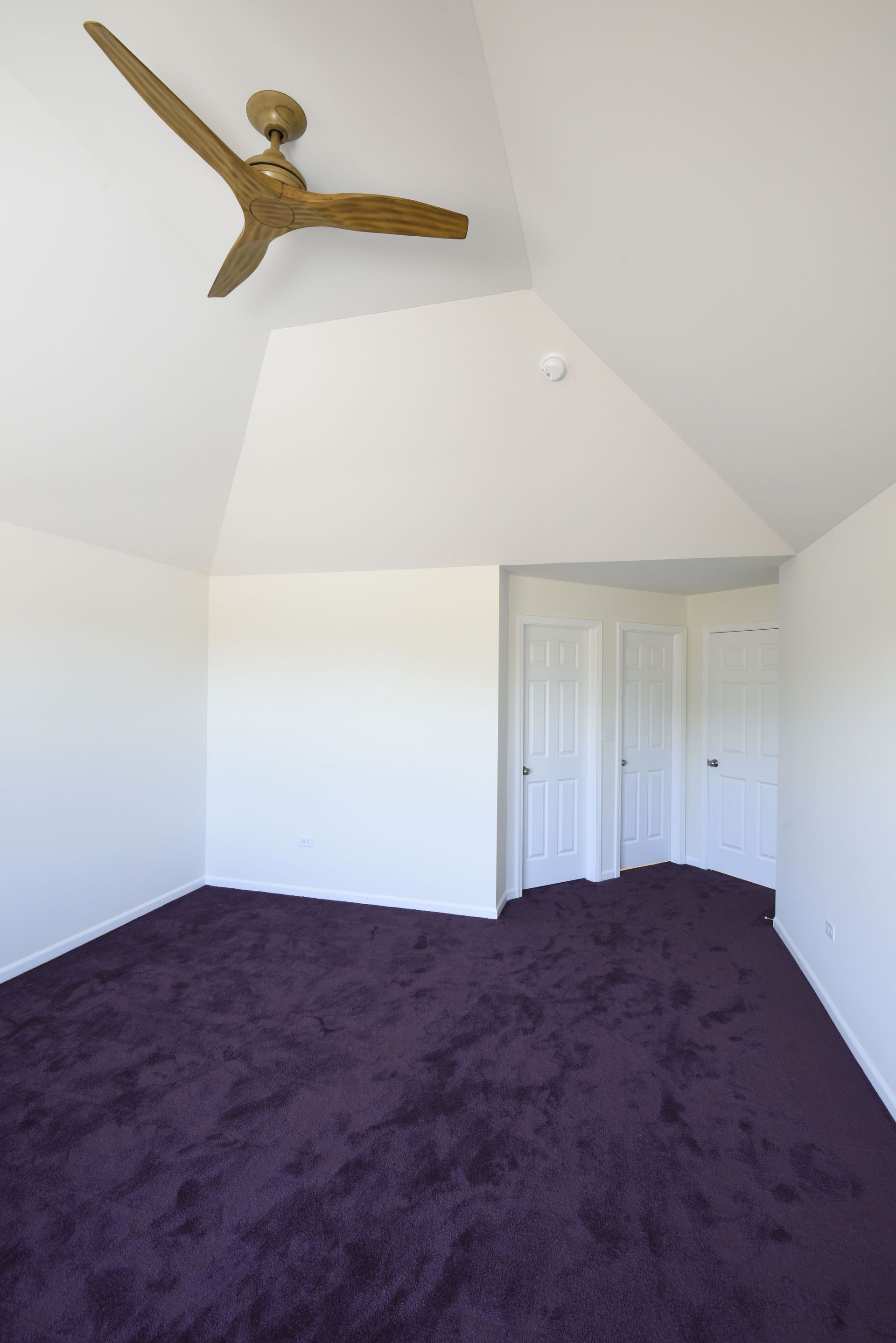 A kitchen with white cabinets, stainless steel appliances, and a large island.