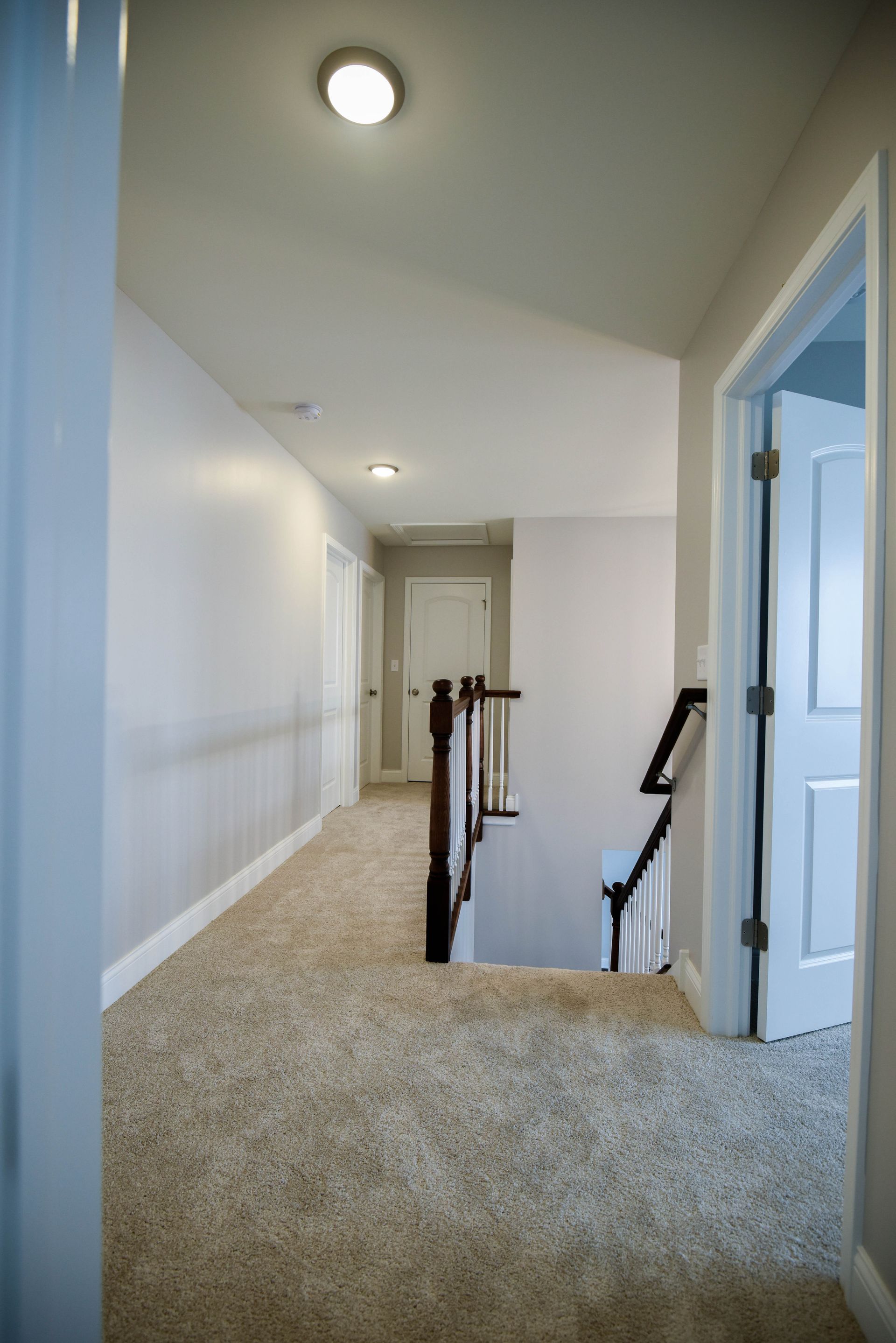 A walk in closet with lots of shelves and a ceiling light.