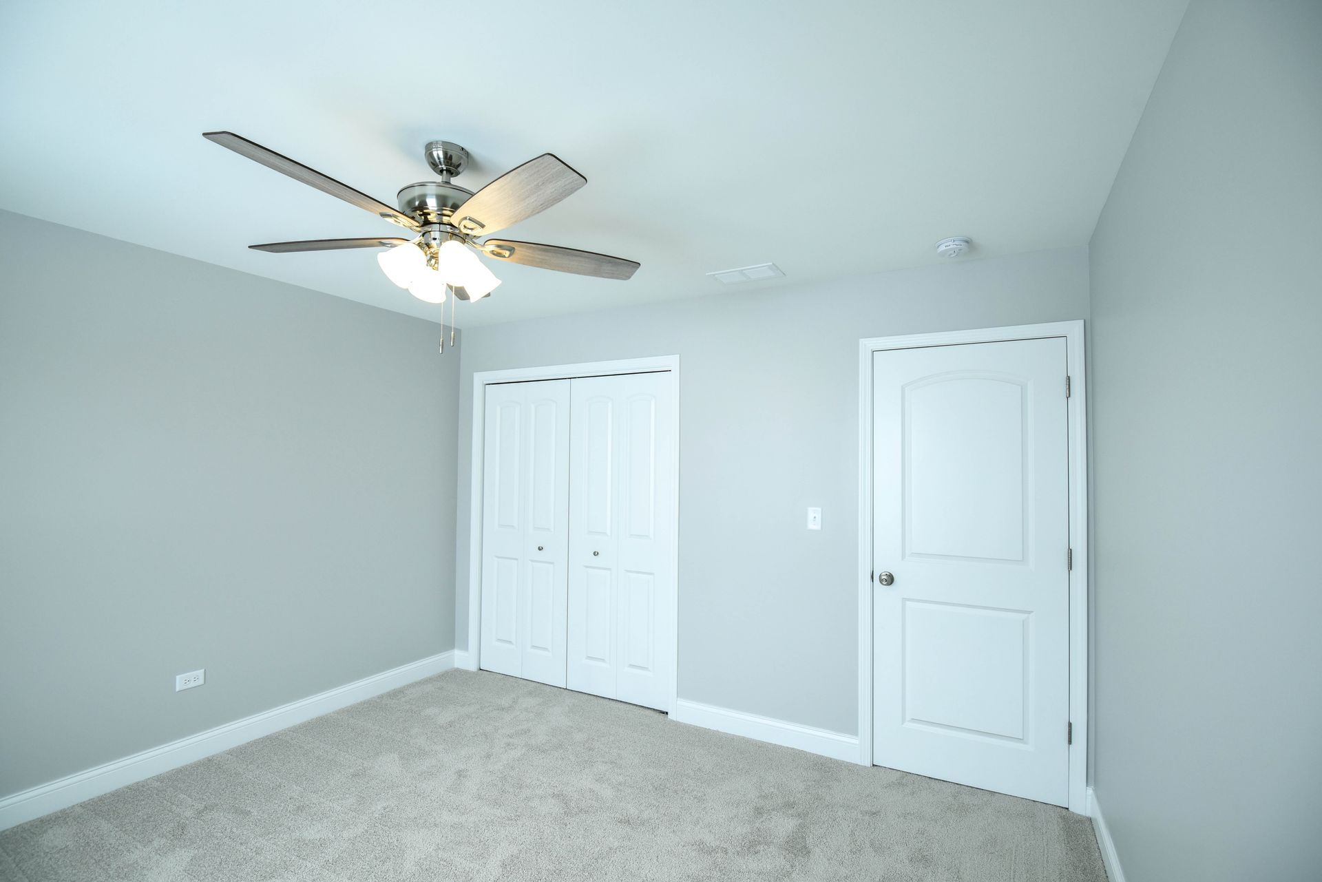 A living room with hardwood floors and a ceiling fan