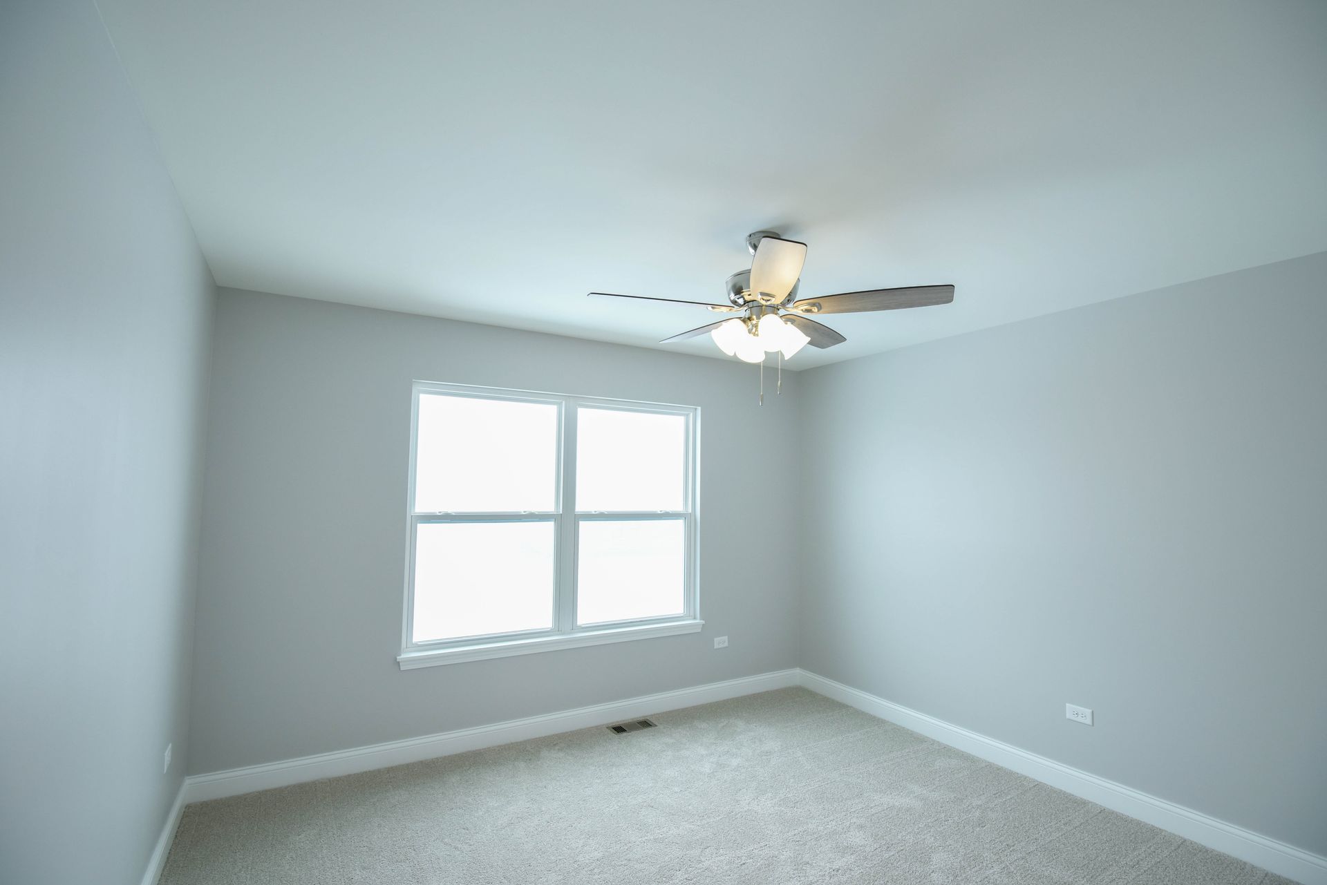 A living room with a ceiling fan and a chandelier