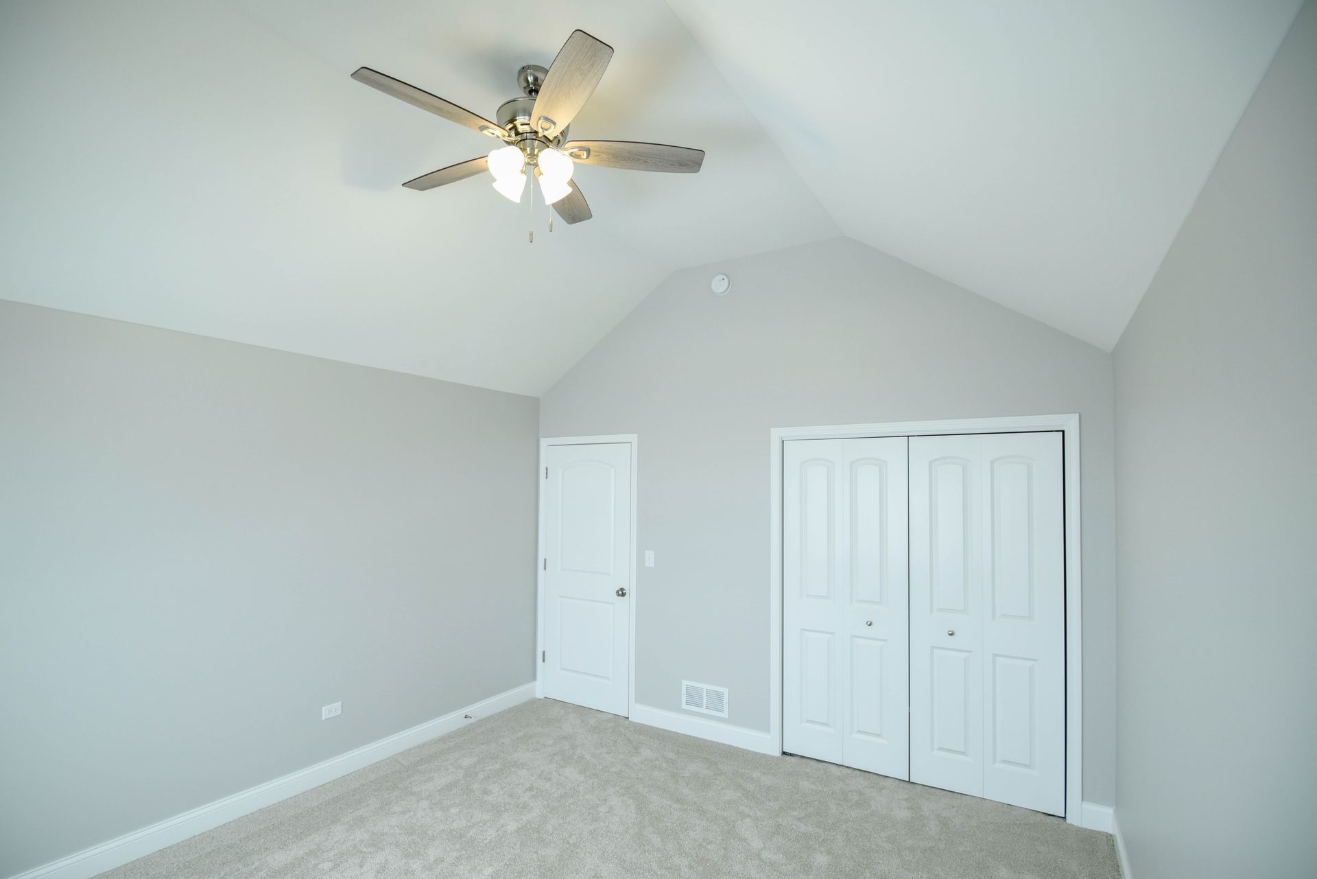 An empty living room with hardwood floors and a fireplace.