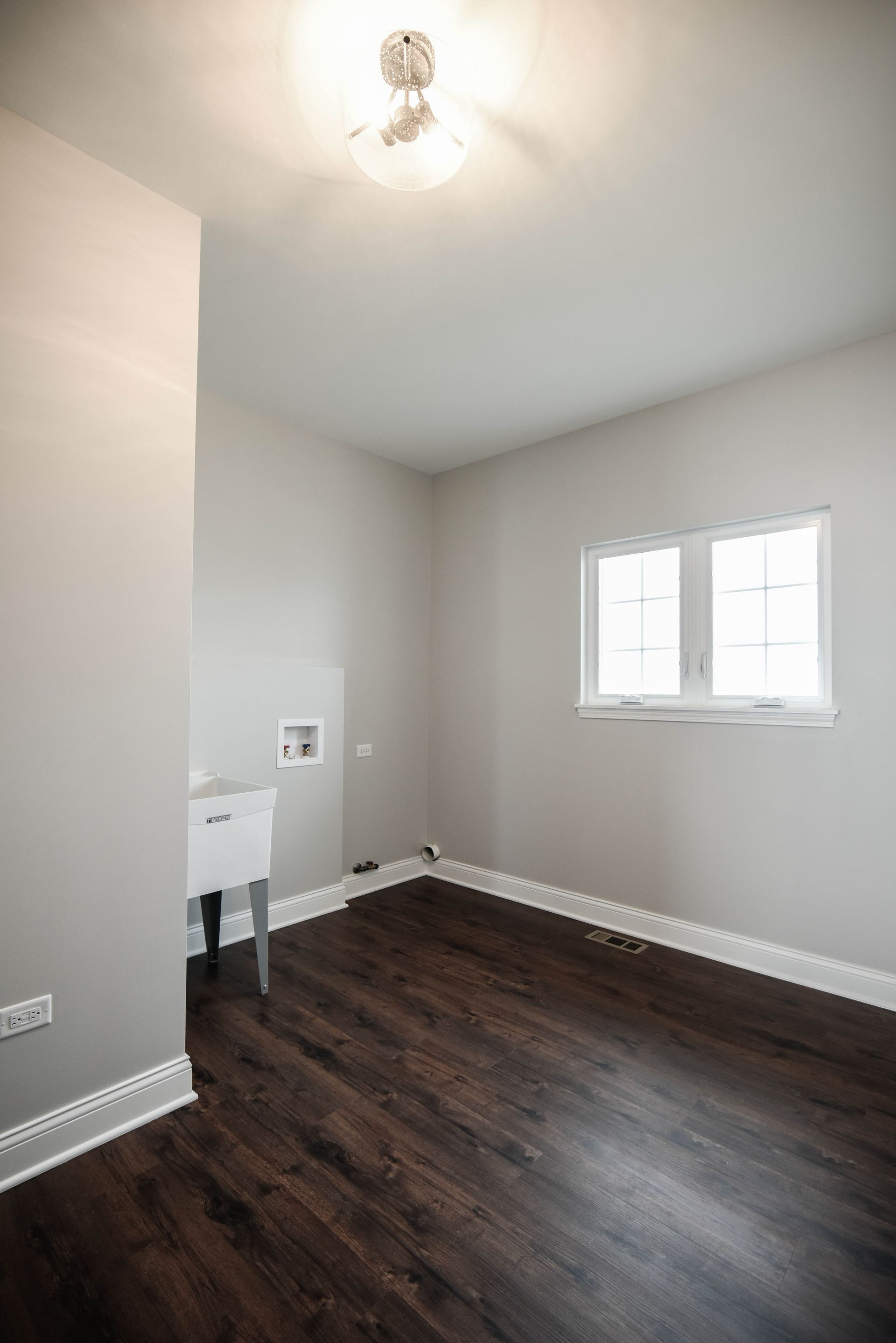 An empty bedroom with a vaulted ceiling and a ceiling fan.