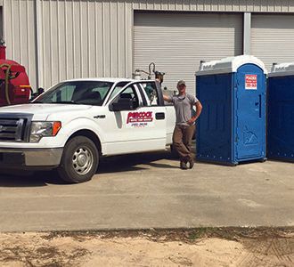 man standing next to truck, Portable toilets