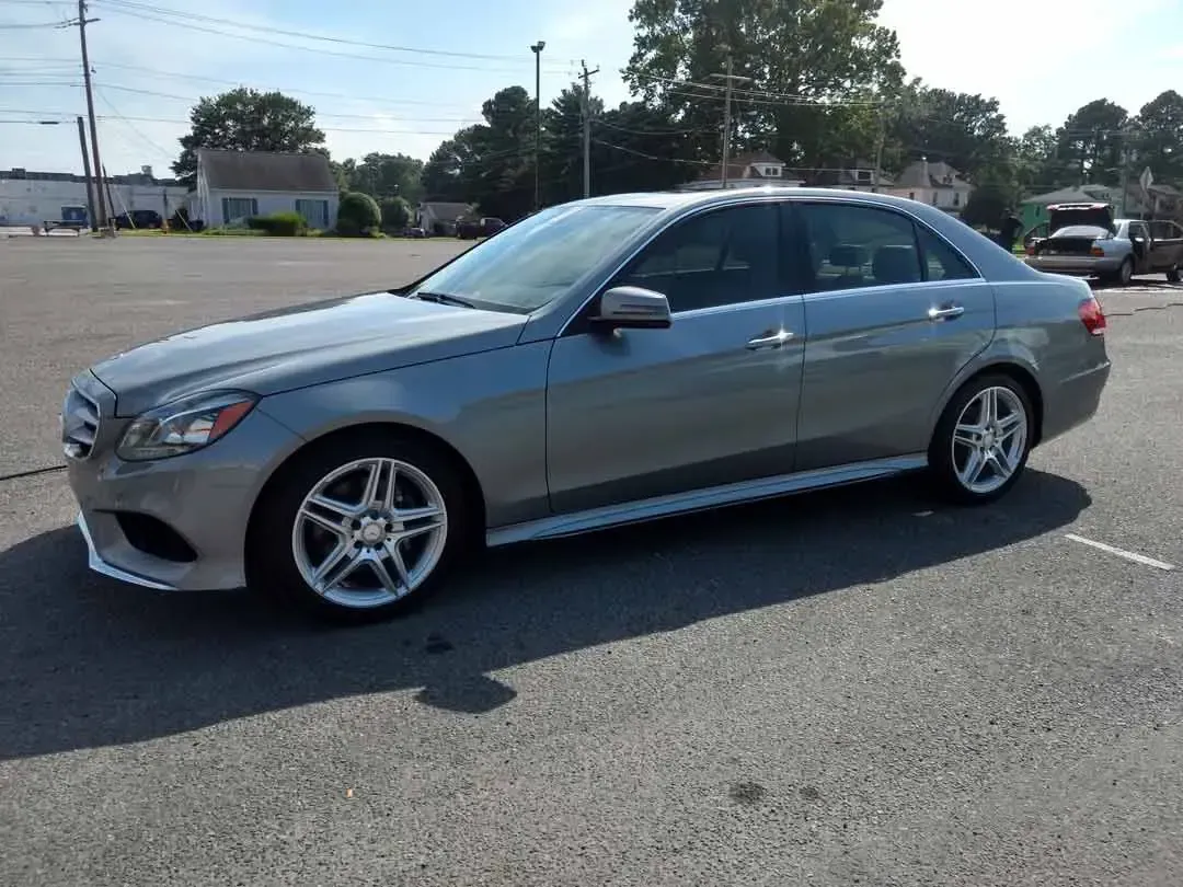 A silver mercedes benz e class is parked in a parking lot.
