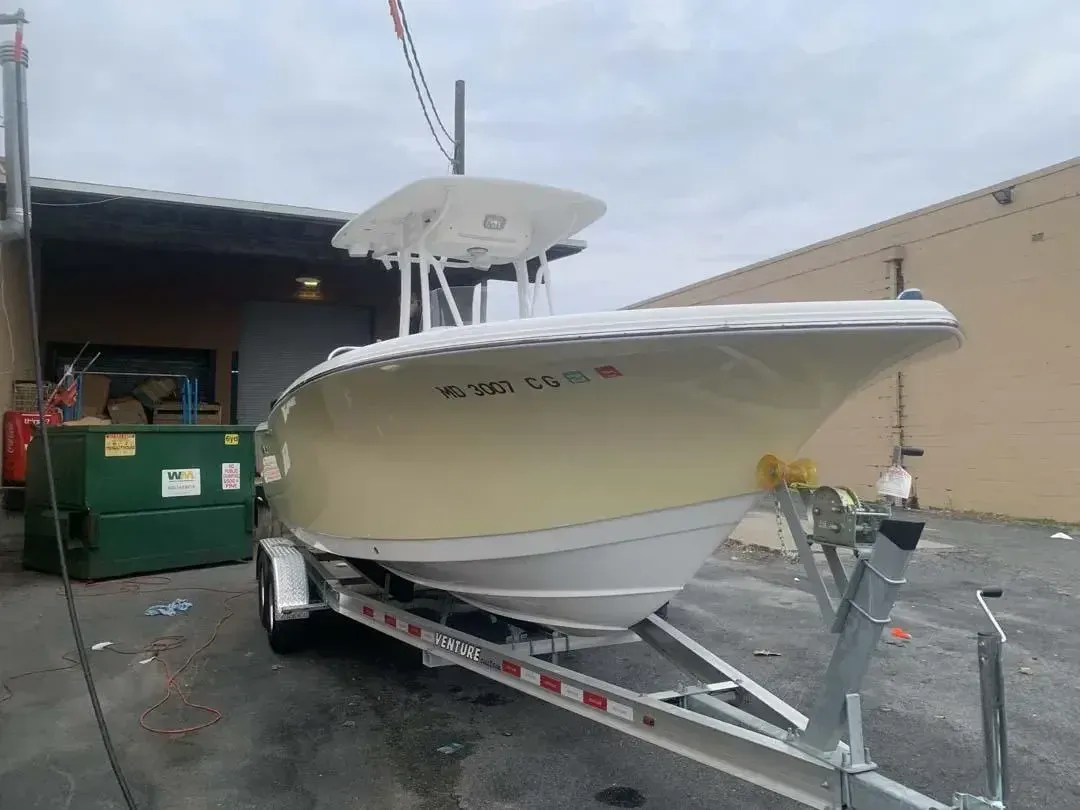 A boat is on a trailer in front of a building.
