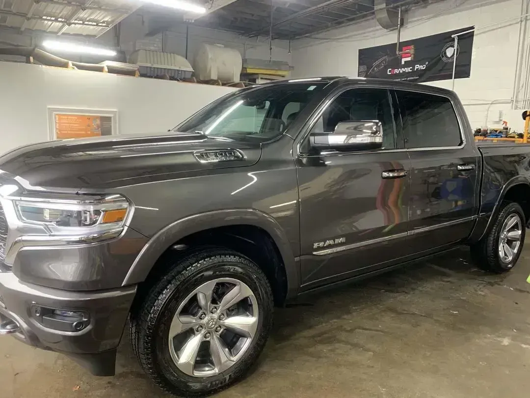 A gray ram 1500 pickup truck is parked in a garage.