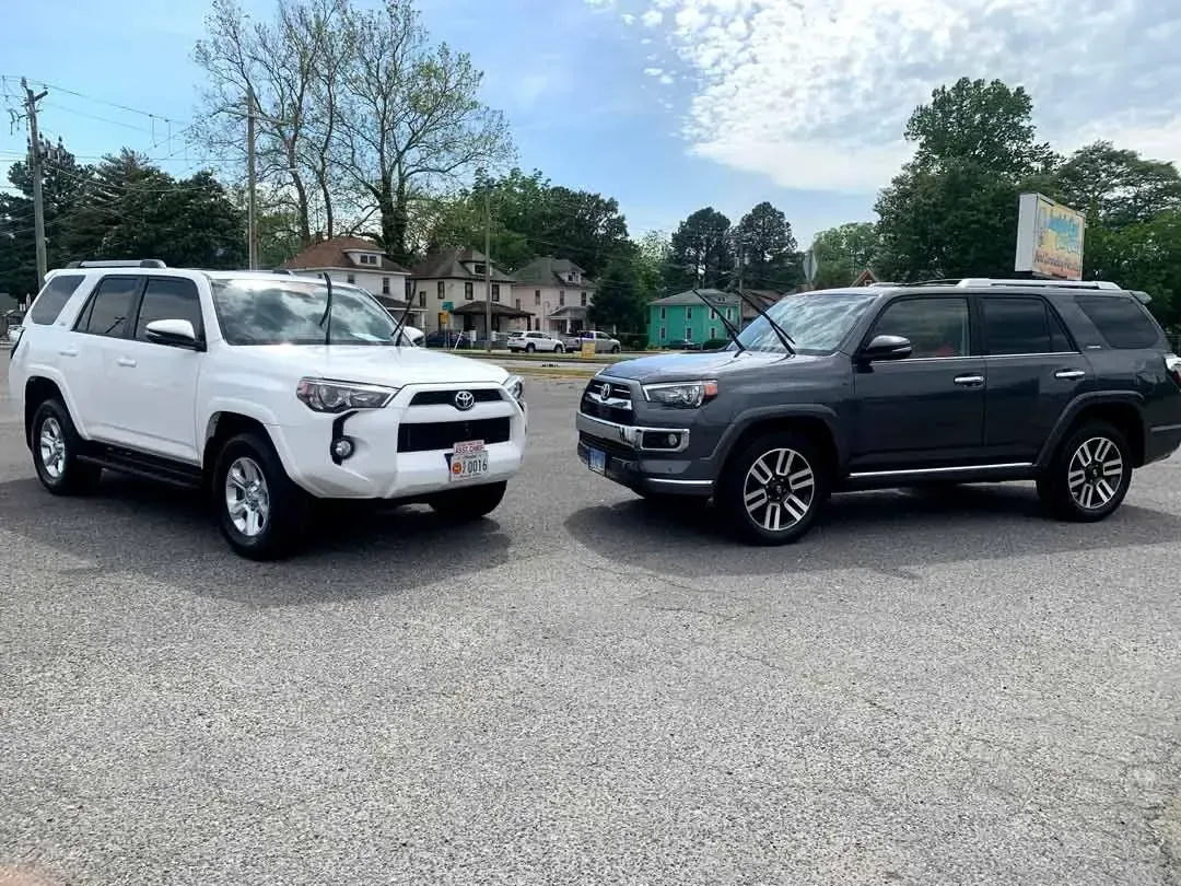 Two toyota 4runner suvs are parked next to each other in a parking lot.