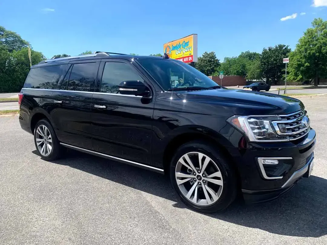 A black ford expedition is parked in a parking lot.