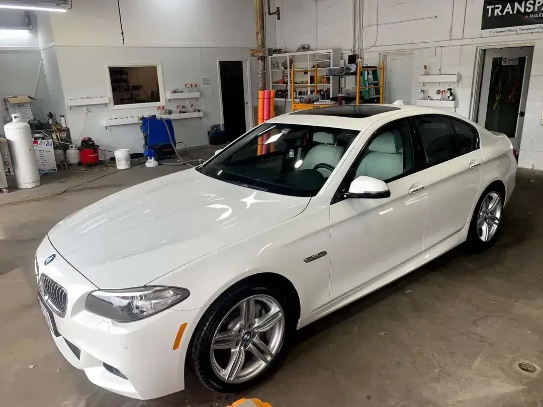 A white bmw is parked in a garage.