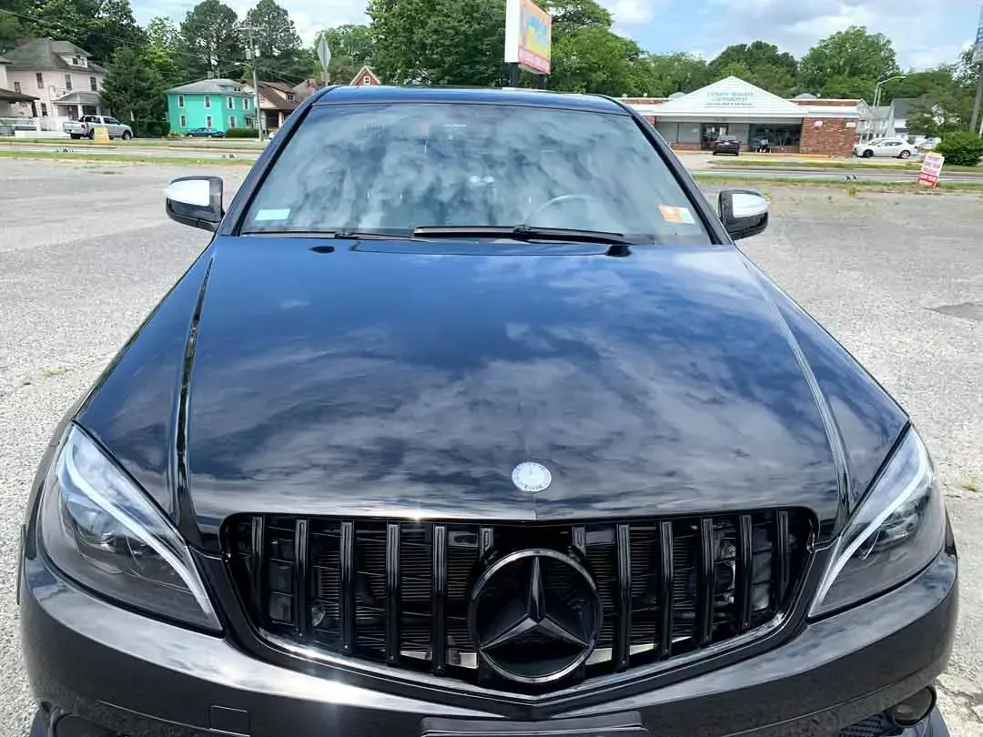 A black mercedes benz is parked in a parking lot.