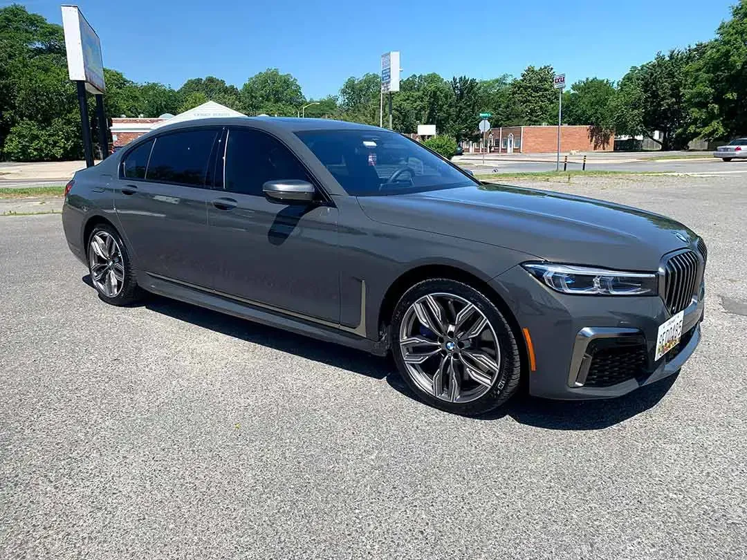 A gray bmw 750li is parked in a parking lot.