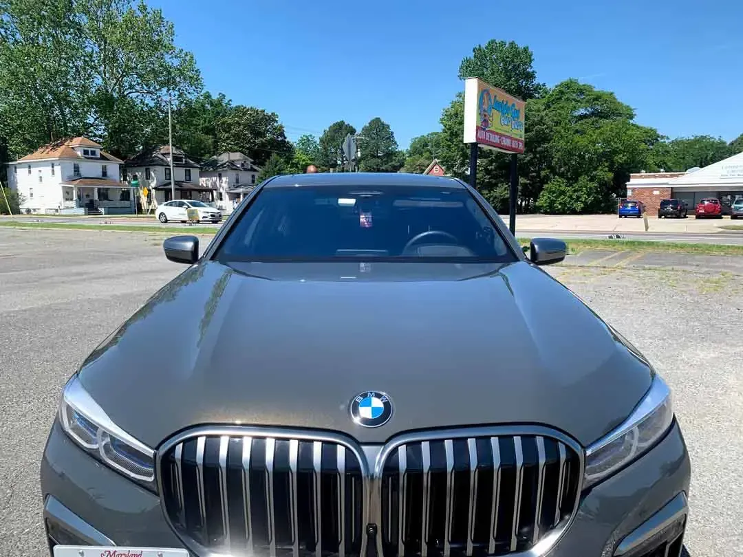 A gray bmw is parked in a parking lot.