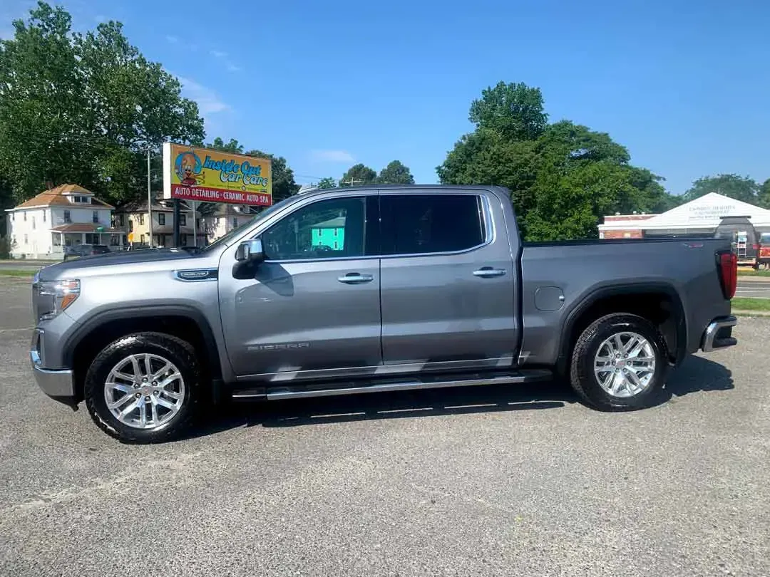 A gray pickup truck is parked in a parking lot.