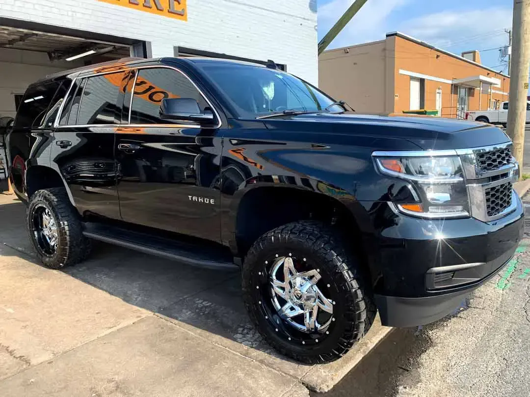 A black suv is parked in front of a garage.