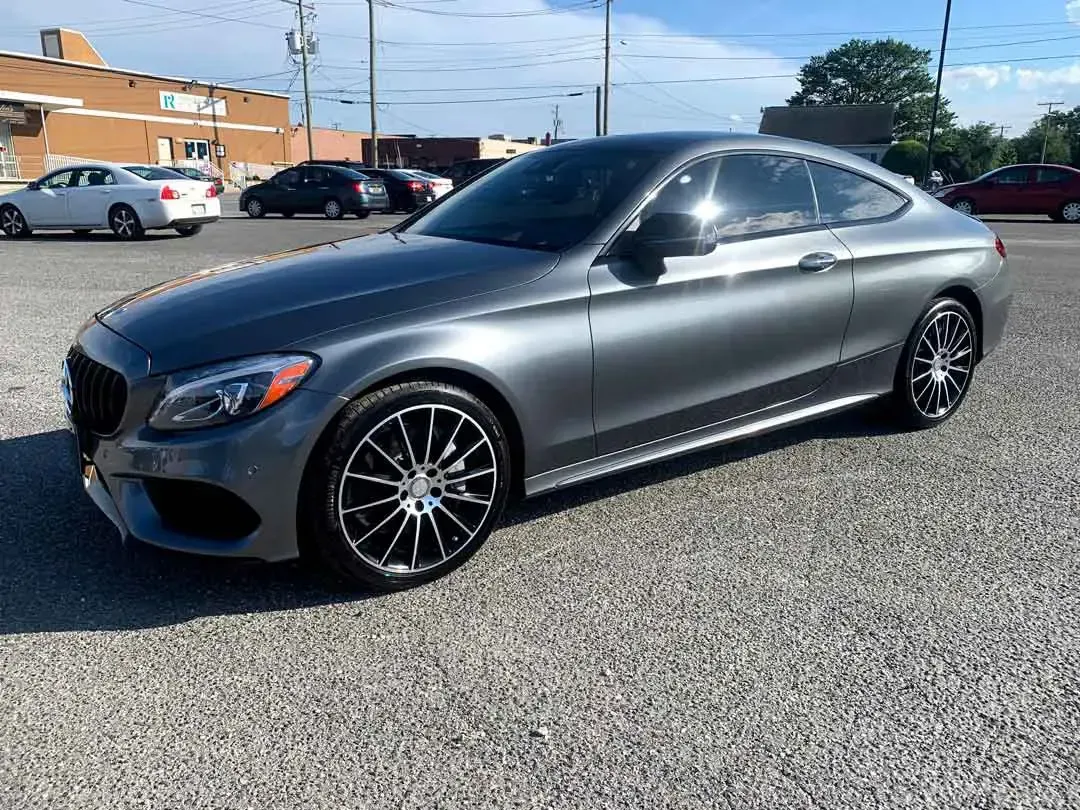 A mercedes benz c class coupe is parked in a parking lot.