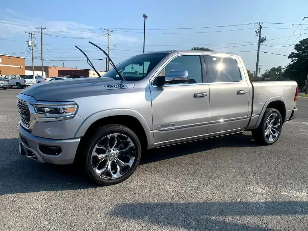A silver ram 1500 truck is parked in a parking lot.